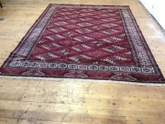 A Turkoman rug, the centre panel with three rows of diamonds, with running dog style borders,