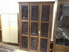 An unusual oak and carved panel wardrobe, incorporating a set of nine Chinese relief carved hardwood