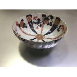 A Chinese porcelain Imari bowl, fluted, decorated with radiating vertical bands of flowerheads to