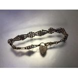 A 9ct gold fancy link bracelet, composed of lozenge-form links, on a heart padlock clasp, with