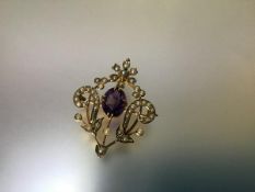 A 9ct gold brooch pendant, set with an amethyst and seed pearls, the oval-cut stone claw-set in a