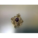 A 9ct gold brooch pendant, set with an amethyst and seed pearls, the oval-cut stone claw-set in a