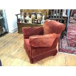 A small upholstered club chair, early 20th century, with outscrolled arms flanking a loose-cushioned