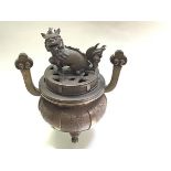 A Chinese bronze censer, of circular bellied form, the cover mounted with a kylin finial, the body
