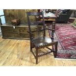 An early 19th century oak country open armchair, with shaped horizontal splat above a plank seat