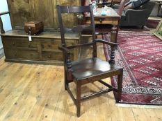 An early 19th century oak country open armchair, with shaped horizontal splat above a plank seat