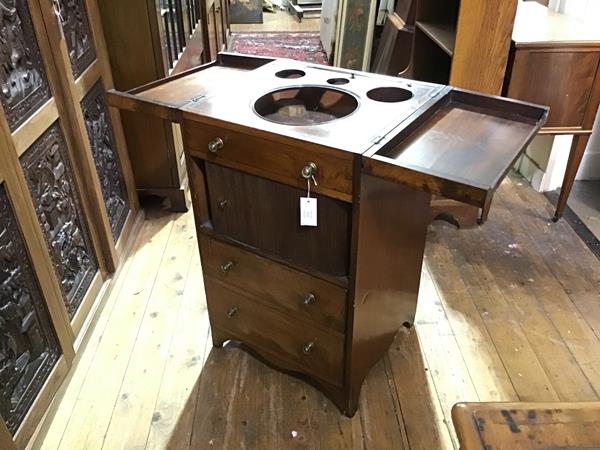 A George III mahogany washstand, the rectangular fold-out top opening to a fitted interior with