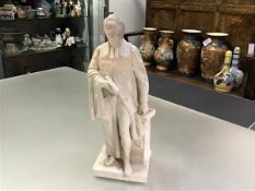 A 19th century parian figure of a standing cleric, in his right hand a scroll, his left resting upon