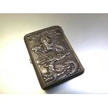 A Chinese silver cigarette case, c. 1910, chased to each side in relief with dragons amidst