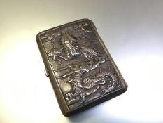 A Chinese silver cigarette case, c. 1910, chased to each side in relief with dragons amidst