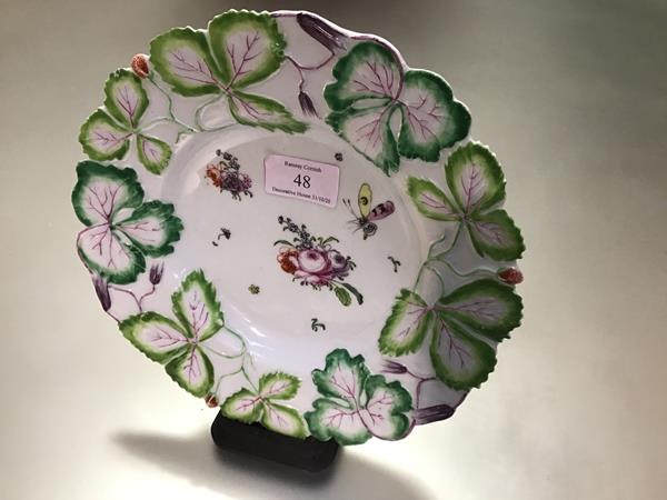 A Longton Hall porcelain "Strawberry Leaf" plate, c. 1755-60, enamel painted to the well with floral