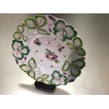 A Longton Hall porcelain "Strawberry Leaf" plate, c. 1755-60, enamel painted to the well with floral