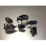 A small collection of Edwardian silver and white metal zoomorphic pin cushions, comprising: a