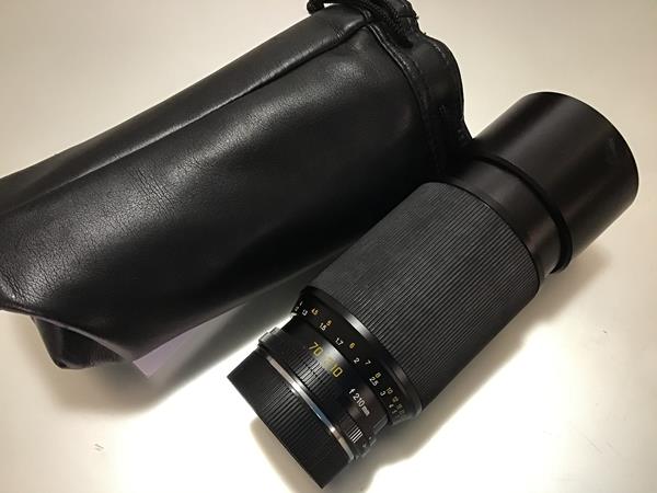 A Leica 70-210mm F4 Vario-Elmar-R lens (lens hood dented) in a soft carry case