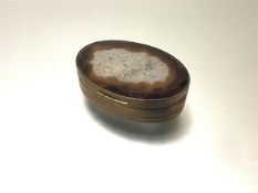 A 19th century gilt-metal mounted agate snuff box, oval, the mounts with engraved wavy bands.