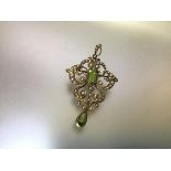 An Edwardian 15ct gold peridot and seed pearl brooch/pendant