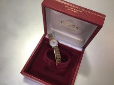 An Omega lady's 9ct gold wristwatch on a 9ct gold bracelet strap, the circular silvered dial with