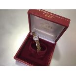 An Omega lady's 9ct gold wristwatch on a 9ct gold bracelet strap, the circular silvered dial with