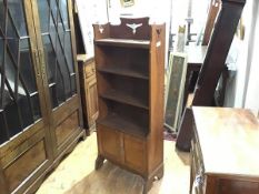 An Arts & Crafts open bookcase, the top shelf with pierced gallery over three further shelves and