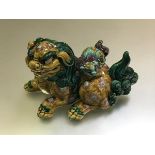 A Chinese biscuit model of a recumbent Buddhist lion dog, the vessel with cover modelled as it's