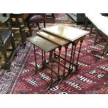 A set of three Regency style mahogany nesting tables, each with rectangular dished top, raised on