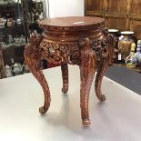 A Chinese carved hardwood vase or jardiniere stand, the circular top carved with a dragon within a