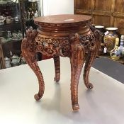 A Chinese carved hardwood vase or jardiniere stand, the circular top carved with a dragon within a