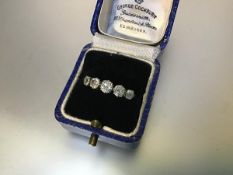 A five stone diamond ring, early 20th century, claw-set with a graduated row of round brilliant-