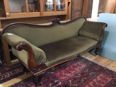 An early Victorian mahogany framed scroll-end sofa, the carved serpentine back above a stuffed