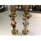 A pair of German porcelain figural table lamps, probably Volkstedt, c. 1920, modelled as a lady