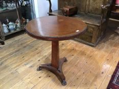 A Regency amboyna tripod table, the circular top with beaded rim on a concave tapering standard over