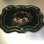 A 19th century painted tole-ware tray, of cartouche shape, decorated with a floral wreath