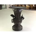 A Chinese patinated bronze vase, of Gu shape, with baluster body, applied with the figure of a
