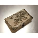 A carved ivory notecase, c. 1900, the cover in relief with dragonflies and a floral spray,