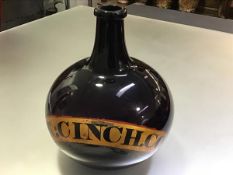 A large 19th century amethyst glass pharmacy bottle, with red-lined gilt label "Tr:Cinch.Co",