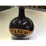 A large 19th century amethyst glass pharmacy bottle, with red-lined gilt label "Tr:Cinch.Co",