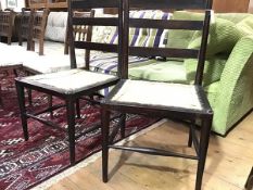 A pair of Arts & Crafts ebonised chairs, c. 1900, each ladder back above a formerly caned seat,