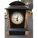 A Victorian slate mantle clock, the marble body with granite slips, with enamelled dial and roman