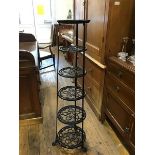 A 19th century style cast iron pan stand, of six graduated and pierced tiers, raised on paw feet (