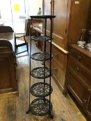 A 19th century style cast iron pan stand, of six graduated and pierced tiers, raised on paw feet (