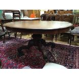 A Victorian mahogany dining table, the carouche-shaped top raised on a spiral turned column and