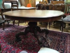 A Victorian mahogany dining table, the carouche-shaped top raised on a spiral turned column and