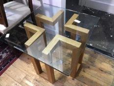 A modern glass and oak framed coffee table, the geometric base supporting a glass top (49.5 x 60 x