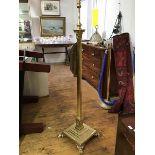 An Edwardian brass Corinthian column floor lamp, the fluted shaft raised on a stepped base and paw