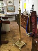 An Edwardian brass Corinthian column floor lamp, the fluted shaft raised on a stepped base and paw