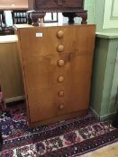 A 1960s teak chest of six graduated drawers, with bun handles, raised on a plinth base (71.5 x 69