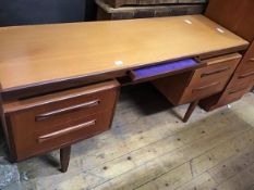 A G-Plan teak dressing table, with velvet-lined frieze drawer and four further drawers, raised on