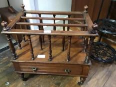 A 19th century walnut Canterbury c.1890, with three divisions above a drawer, raised on turned