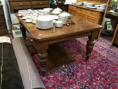 A late Victorian oak telescopic dining table, the rectangular top enclosing three additional leaves,