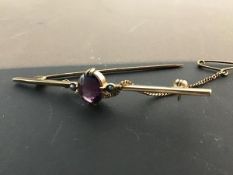 A 9ct gold amethyst and seed pearl set bar brooch,complete with safety chain (3.47g)